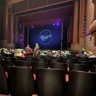 a stage with people sitting in chairs