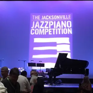 a man playing a piano on stage