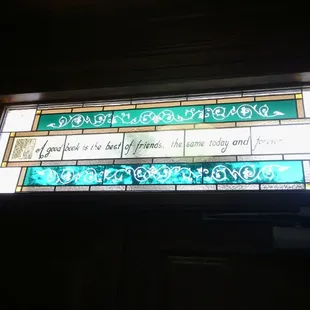 Stained glass above the front door of the library. "A good book is the best of friends, the same today &amp; forever."