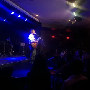  a man playing guitar on stage