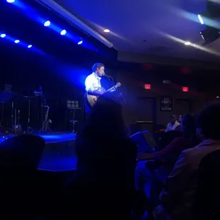  a man playing guitar on stage
