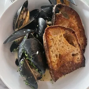 a plate of steamed mussels and bread