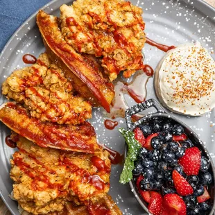 a plate of french toast with berries and whipped cream