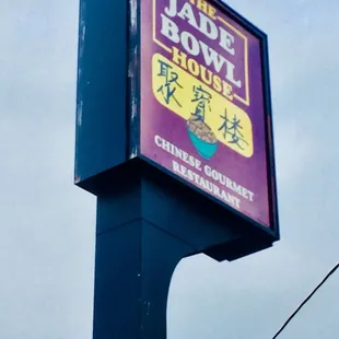 Lighted street sign is taller than the restaurant.