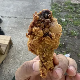 a hand holding a fried chicken