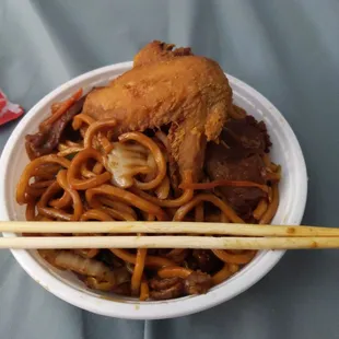 a bowl of noodles with meat and chopsticks