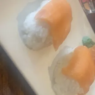 two sushi rolls on a white plate