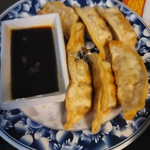 a plate of dumplings and dipping sauce