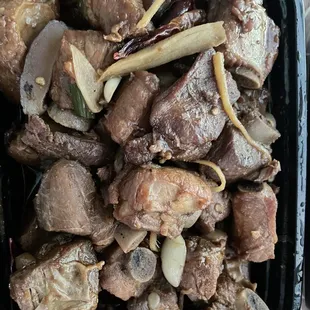 beef and onions in a black container