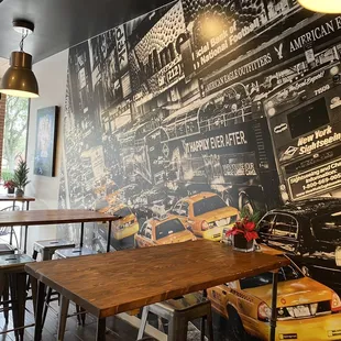 tables and chairs in front of a mural