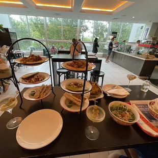 a table with plates of food and glasses of wine