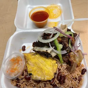 Fried goat (Tassot) green fried plantain, rice and peas and picklees