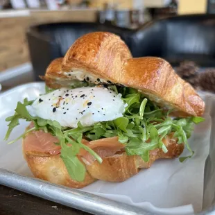 a croissant sandwich with an egg and lettuce