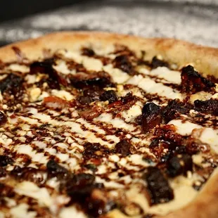The Sweet Swine - Garlic infused EVOO, garlic, hand-pulled mozzarella, sweet pork belly, goat cheese, roasted tomatoes, balsamic reduction.