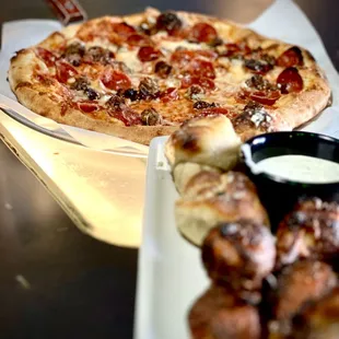 a plate of chicken wings and a pizza