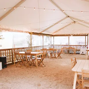 the inside of a tent with tables and chairs