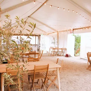 tables and chairs under a tent