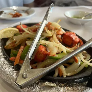 a plate of food with tongs