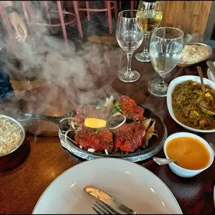 Steam rises from sizzling rack of lamb entree.