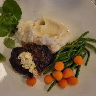 Pork chop with apple cherry chutney, garlic mashed potatoes and vegetables .