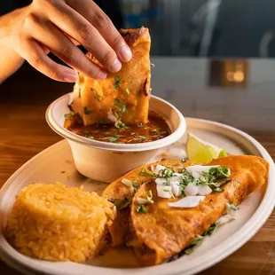 a person dipping a piece of bread into a bowl of salsa