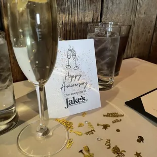 a glass of champagne and a card