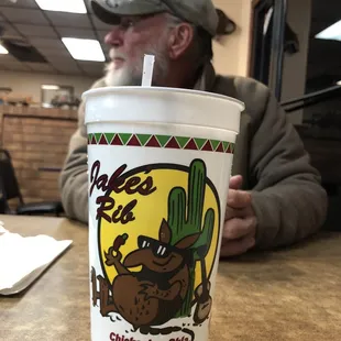 a man sitting at a table with a drink in his hand