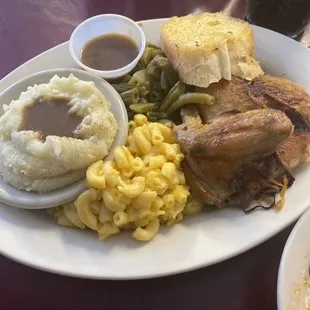 Baked  Chicken mashed Potatoes a gravy Mac and cheese green beans an Garlic  Bread