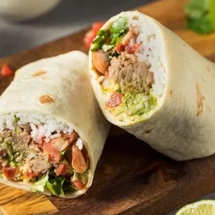 two burritos on a cutting board