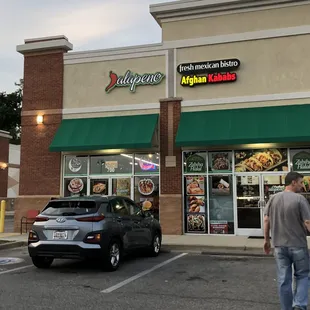 a man walking in front of a restaurant