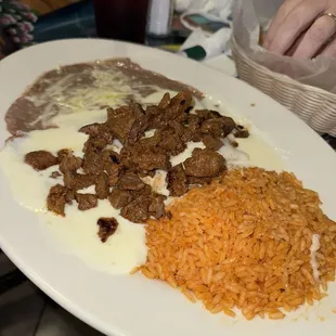 Cheese enchiladas topped with steak and Queso