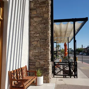 a wooden bench on a sidewalk