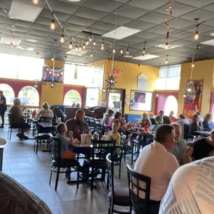 a large restaurant with people sitting at tables