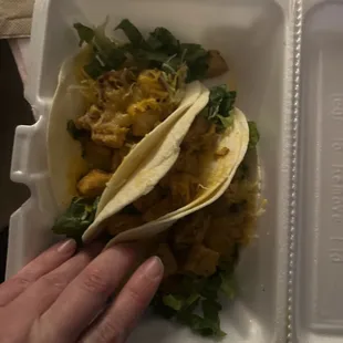 two tacos in a styrofoam container