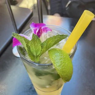 a cocktail with a lime garnish