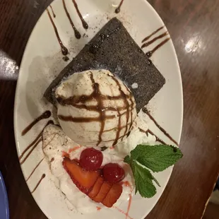 Brownie with chocolate ice cream and strawberries and cream