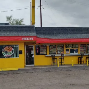 a yellow restaurant with a red awning