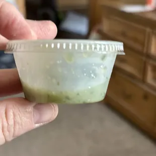 a hand holding a plastic container