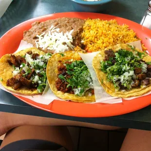 Three tacos. Pol, chorizo, and carne Asada with rice &amp; beans