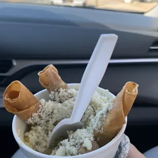 a hand holding a bowl of food