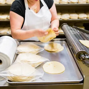 a woman making tortillas