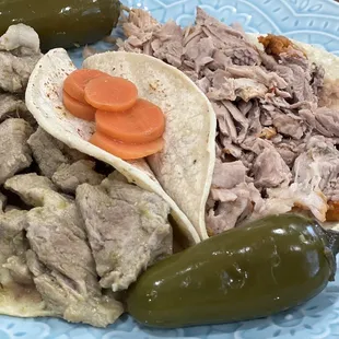 Tacos on dinner plate. Pork in green sauce (L) &amp; carnitas tacos (R) with pickled carrots and jalapeños (on the side) $4.58 each
