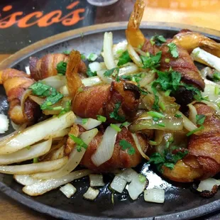 Bacon wrapped prawns stuffed with cream cheese and jalapenos on a bed of grilled onions $11.99