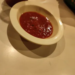 a bowl of sauce on a table