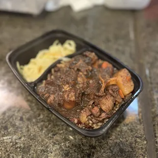 a bowl of stew and noodles