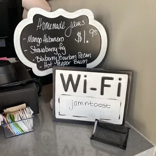 a man sitting at a counter with a blackboard sign