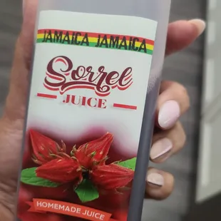 a hand holding a bottle of juice