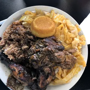 Jerk chicken with rice and peas (beans), double cabbage, and corn bread
