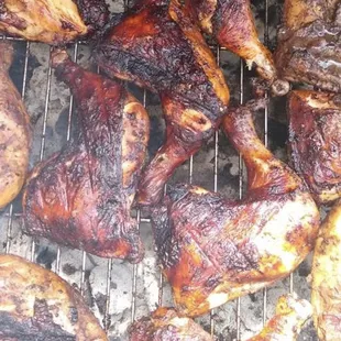 chicken and other meats cooking on a grill