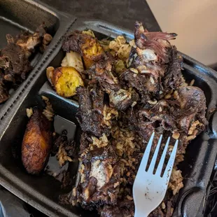 Oxtails bedded on rice +peas, sides: cabbage and candied plantain. Good. Served nice + hot.
